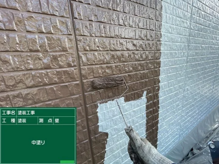 外壁に中塗りをしている写真